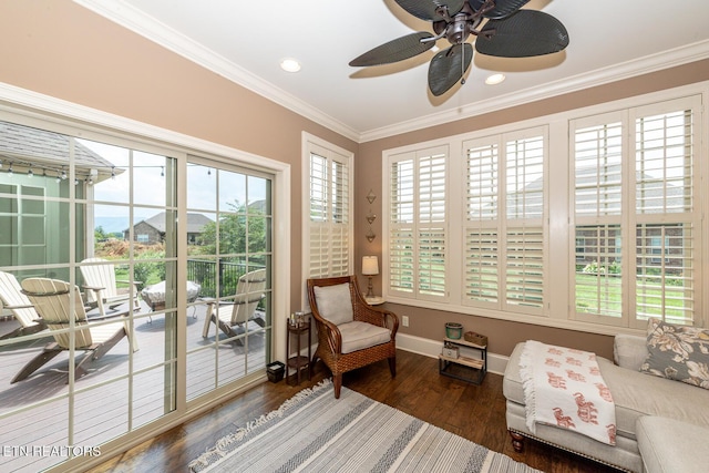 living area featuring a wealth of natural light, wood finished floors, baseboards, and ornamental molding