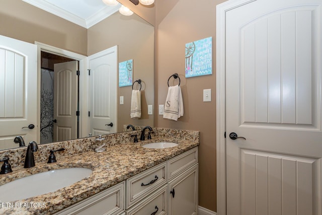 full bath with double vanity, crown molding, and a sink