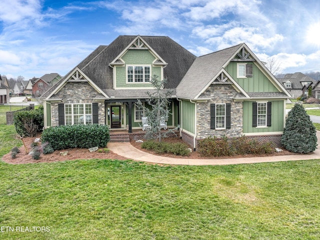 craftsman inspired home with stone siding, board and batten siding, and a front lawn