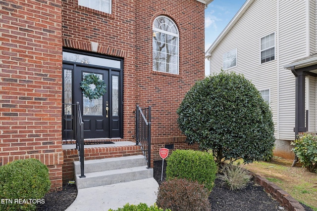 doorway to property featuring brick siding and crawl space