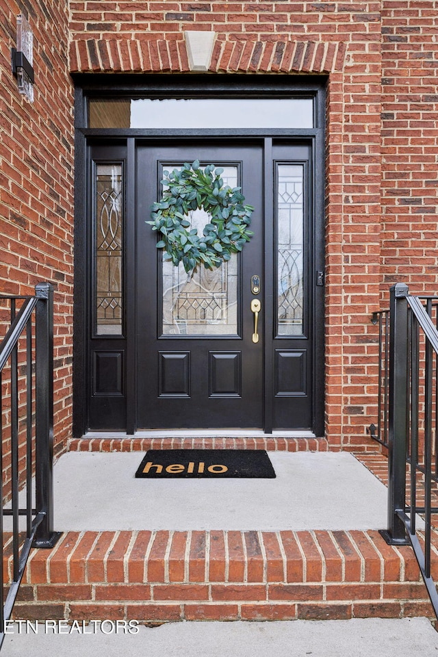 property entrance featuring brick siding