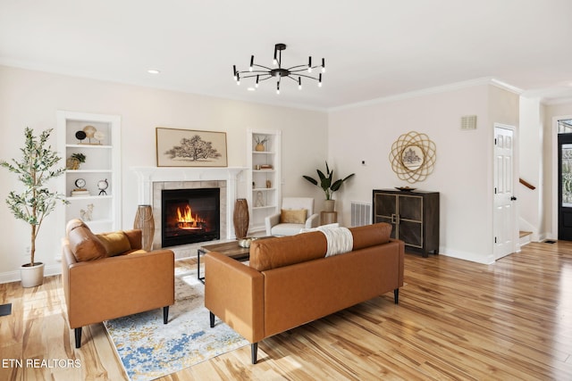 living room featuring visible vents, built in features, baseboards, and light wood-type flooring