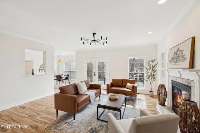 living area with light wood-style floors, french doors, baseboards, and ornamental molding