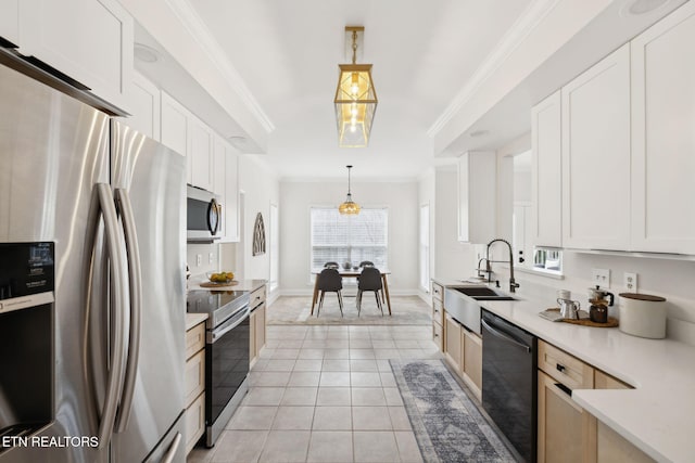 kitchen featuring light tile patterned floors, ornamental molding, appliances with stainless steel finishes, and a sink