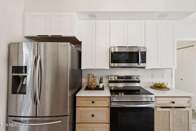 kitchen featuring white cabinets, appliances with stainless steel finishes, and light countertops