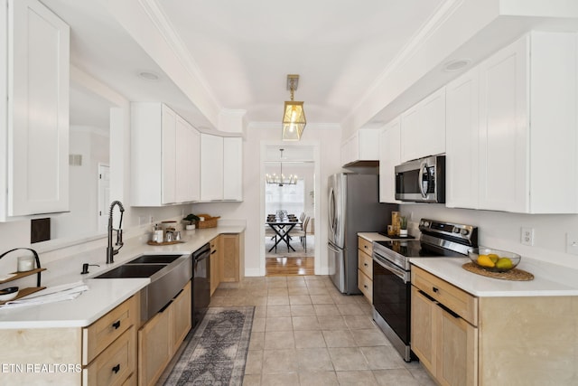 kitchen with crown molding, a chandelier, light countertops, stainless steel appliances, and a sink