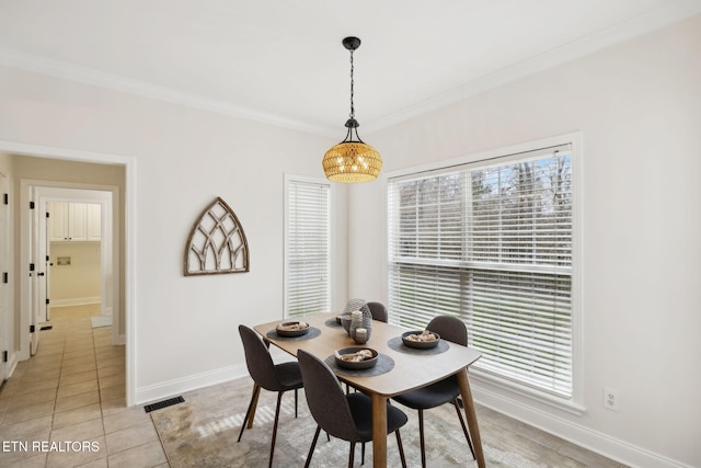 dining space featuring light tile patterned floors, visible vents, baseboards, and ornamental molding