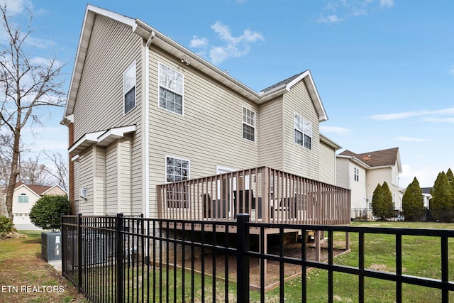 back of property featuring a yard, cooling unit, a deck, and fence