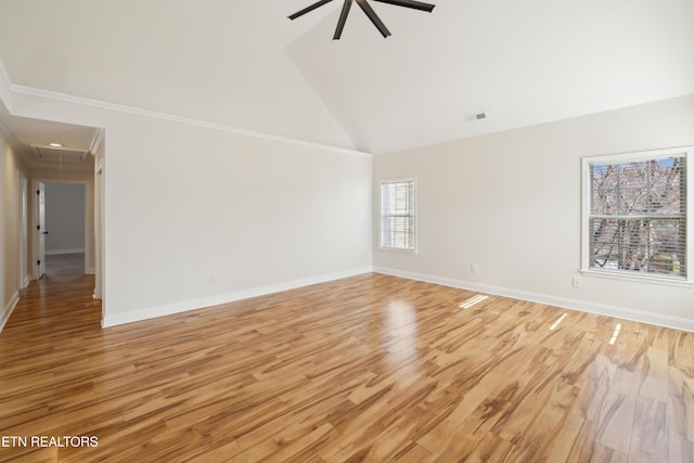 spare room featuring visible vents, baseboards, high vaulted ceiling, attic access, and light wood-style flooring