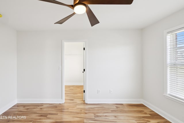 unfurnished room with baseboards, light wood-style flooring, and a ceiling fan