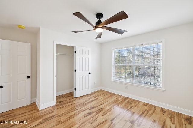 unfurnished bedroom featuring light wood-type flooring, baseboards, a closet, and a ceiling fan