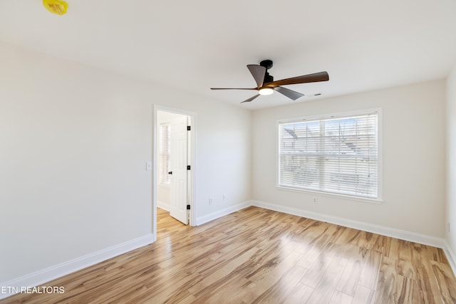 unfurnished room featuring a ceiling fan, baseboards, and light wood-type flooring