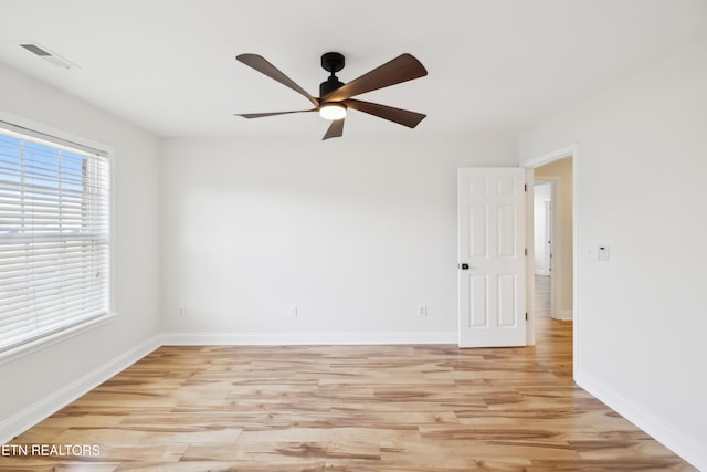 spare room featuring visible vents, baseboards, light wood-style floors, and a ceiling fan