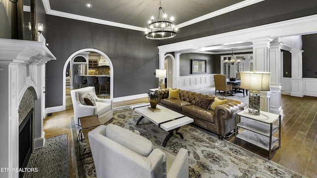 living room with dark wood-style floors, a fireplace, arched walkways, a decorative wall, and a notable chandelier