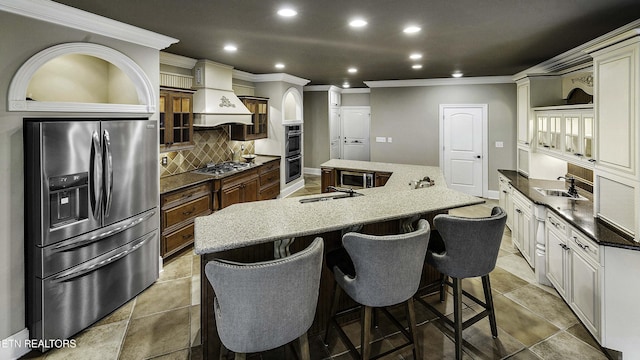 kitchen featuring a large island, a sink, tasteful backsplash, stainless steel appliances, and custom exhaust hood