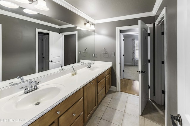 bathroom with tile patterned floors, ornamental molding, and a sink