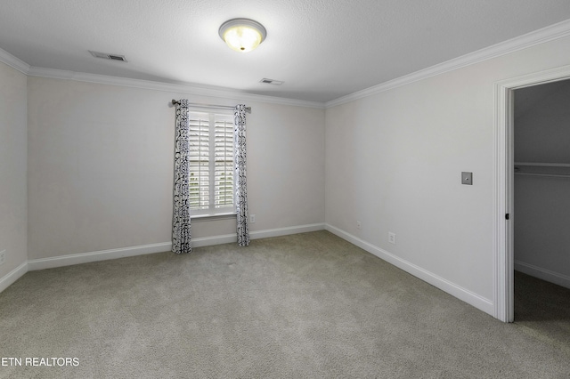 unfurnished bedroom with visible vents, carpet flooring, baseboards, and ornamental molding