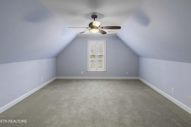 additional living space featuring a ceiling fan, carpet, baseboards, and vaulted ceiling