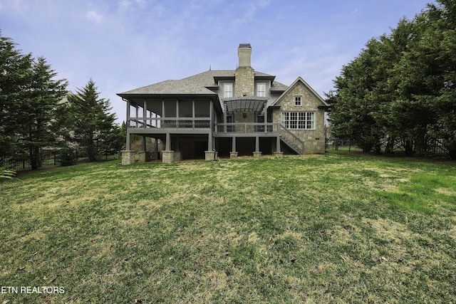 rear view of property with stairway, a lawn, stone siding, and a sunroom