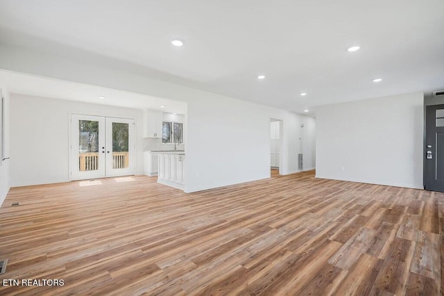 unfurnished living room featuring recessed lighting, french doors, visible vents, and light wood-style flooring