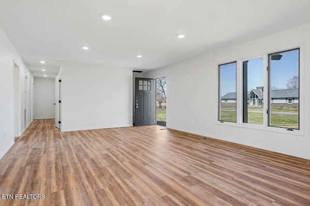 spare room featuring recessed lighting, light wood-type flooring, and baseboards