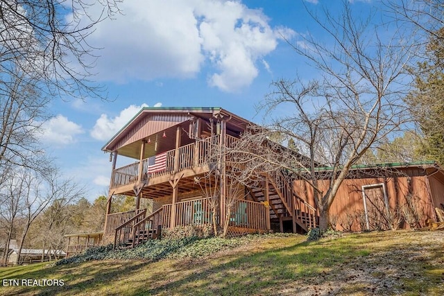 rear view of house featuring a deck and stairway