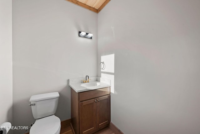 bathroom featuring baseboards, toilet, and vanity