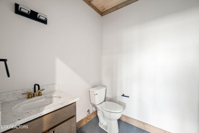 bathroom with vanity, toilet, and baseboards