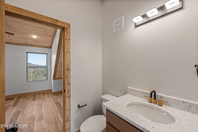 bathroom with vanity, wood finished floors, baseboards, wood ceiling, and toilet