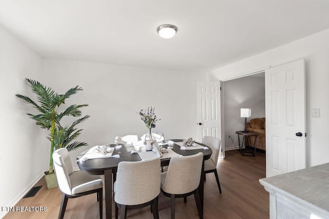 dining area with wood finished floors, visible vents, and baseboards