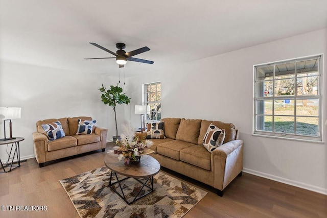 living area featuring wood finished floors, baseboards, a wealth of natural light, and ceiling fan