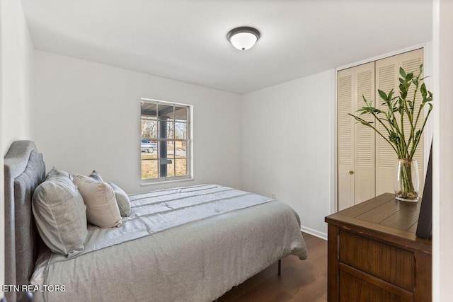 bedroom with a closet, baseboards, and dark wood-type flooring