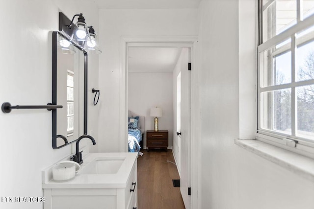 bathroom featuring ensuite bath, wood finished floors, and vanity