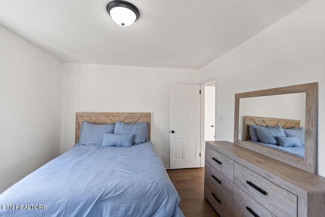 bedroom with dark wood-style flooring