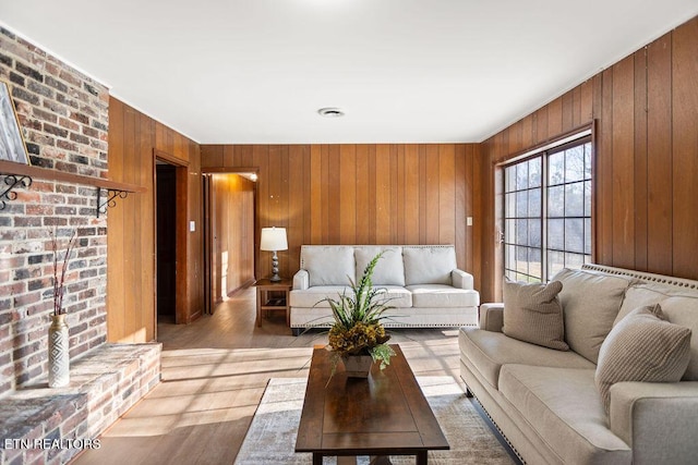 living area with light wood-style floors and wood walls