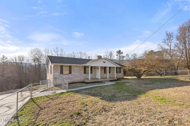 view of front of property featuring brick siding, a front lawn, fence private yard, and covered porch