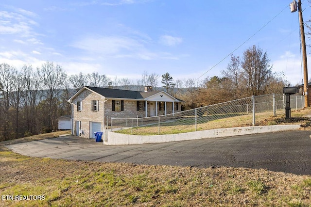 view of front facade featuring an attached garage, fence, driveway, and a chimney