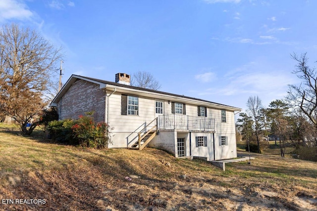 back of house with stairway and a chimney