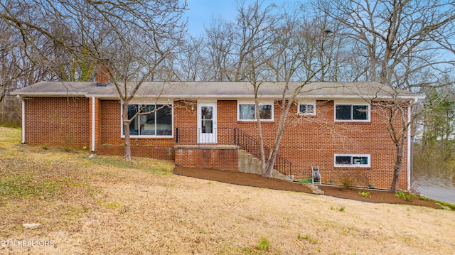 view of front of property with brick siding and a front lawn