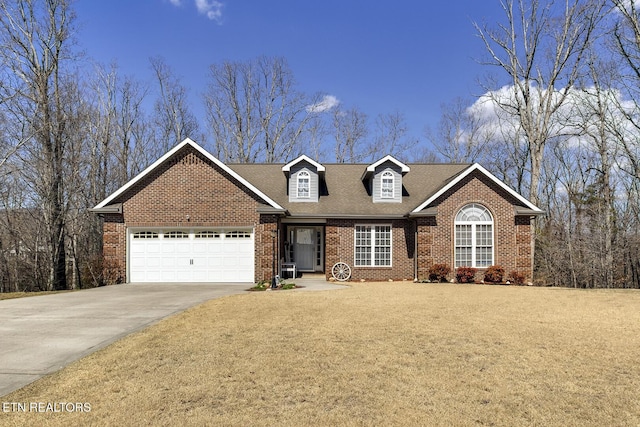 view of front of property with a shingled roof, concrete driveway, a front lawn, a garage, and brick siding