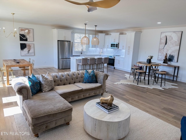 living room with light wood-style flooring and ornamental molding