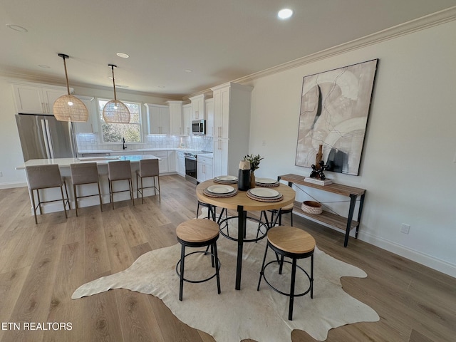 dining space featuring recessed lighting, baseboards, light wood-style flooring, and crown molding