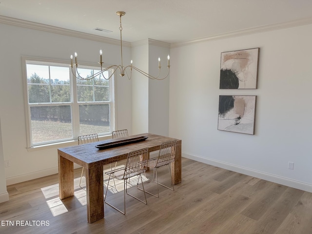 unfurnished dining area featuring baseboards, a chandelier, crown molding, and light wood finished floors