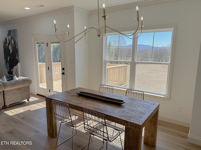 dining space featuring visible vents, a healthy amount of sunlight, wood finished floors, and ornamental molding