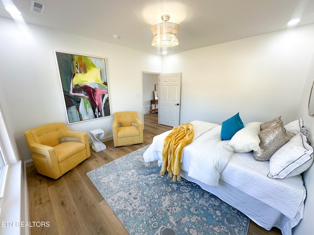 bedroom featuring visible vents and wood finished floors