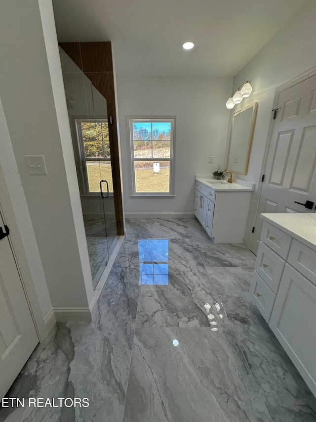 full bathroom featuring marble finish floor, vanity, a shower stall, and baseboards