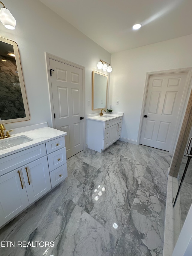 bathroom with a sink, baseboards, two vanities, and marble finish floor