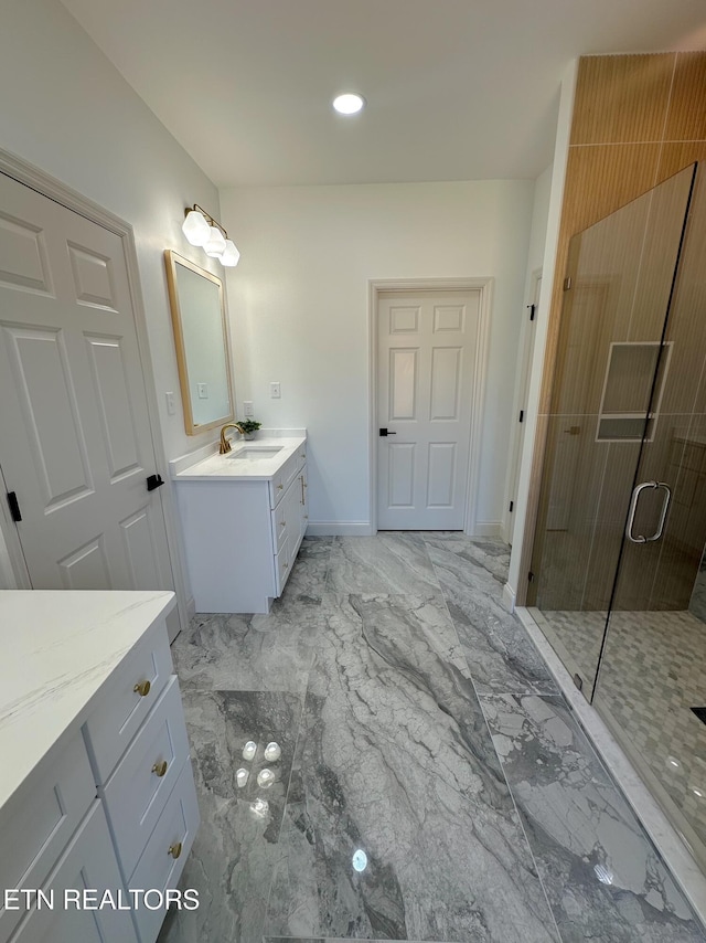 full bath with vanity, baseboards, marble finish floor, and a stall shower