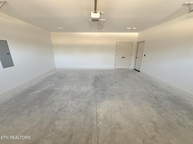 garage with electric panel, a garage door opener, and baseboards