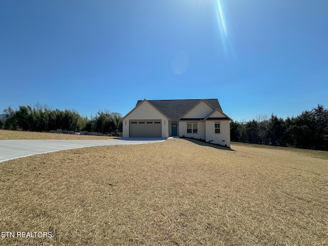 view of front of home featuring driveway, an attached garage, and a front lawn